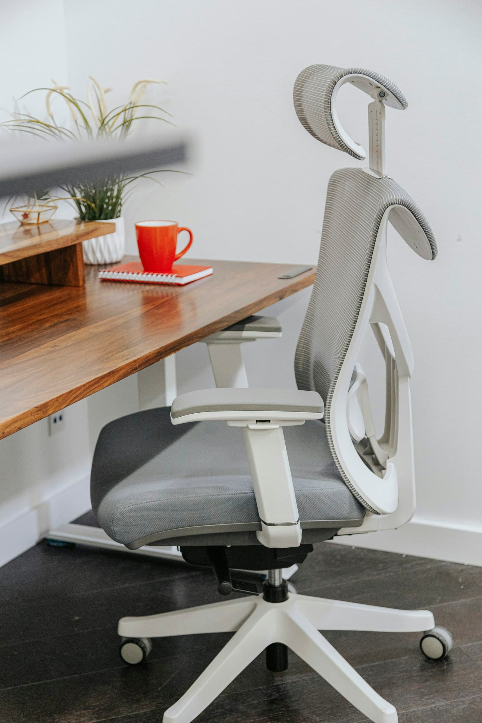 Herman Miller Aeron, remastered: an office chair sitting on top of a wooden desk