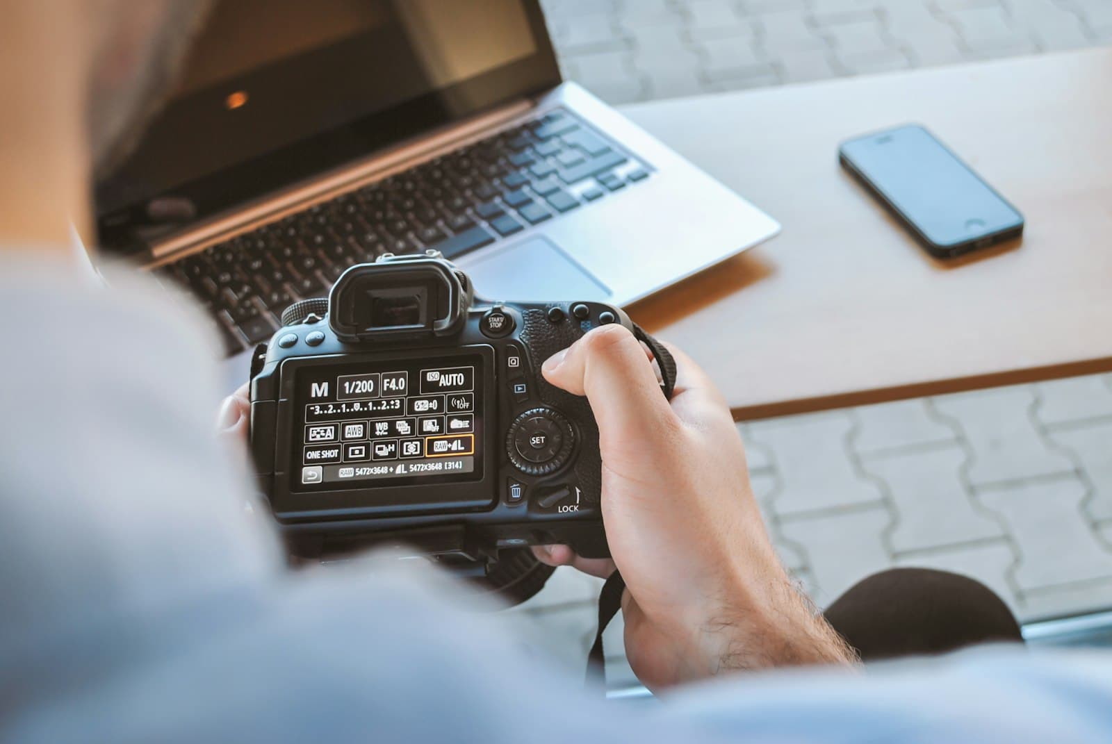 Sony α7 IV: person holding black DSLR camera