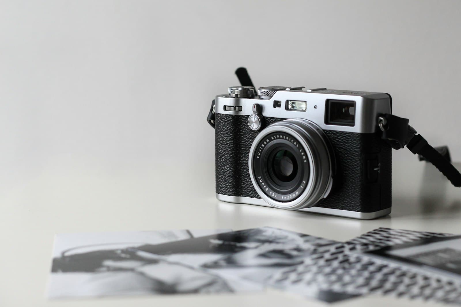 Fujifilm X100F (used): black and gray film camera near printed photos